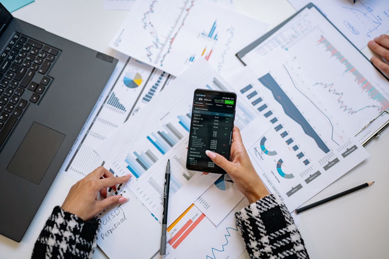 Vue de dessus de graphiques et d’un smartphone dans un bureau, mettant en avant l’analyse de données.